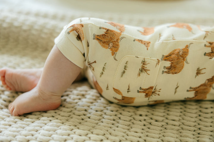 Child wearing Organic S/Sleeve Coverall in Highland Cow.