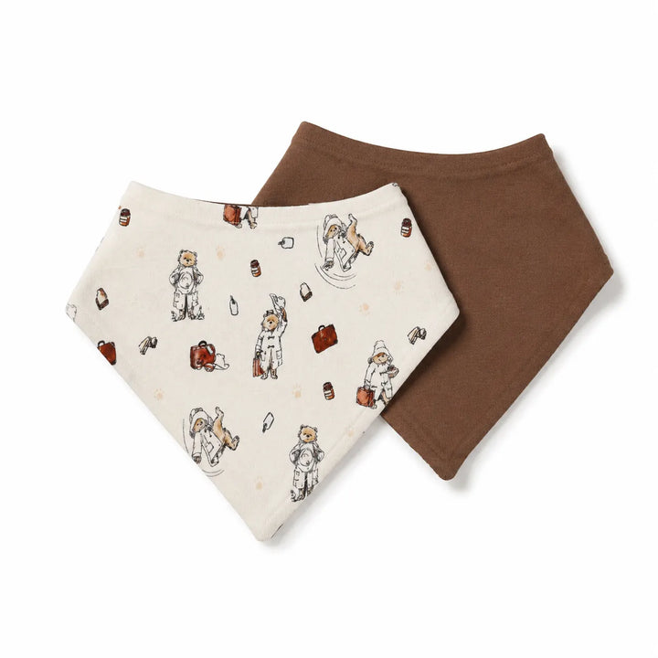 Two triangular bandana bibs, one in cream with a brown and beige teddy bear travel pattern and the other in solid medium brown, displayed on a clean white background.