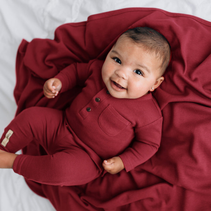 Child with Organic Thermal Swaddling Blanket in Crimson
