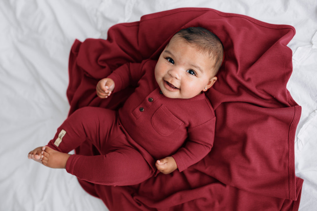 Child with Organic Thermal Swaddling Blanket in Crimson