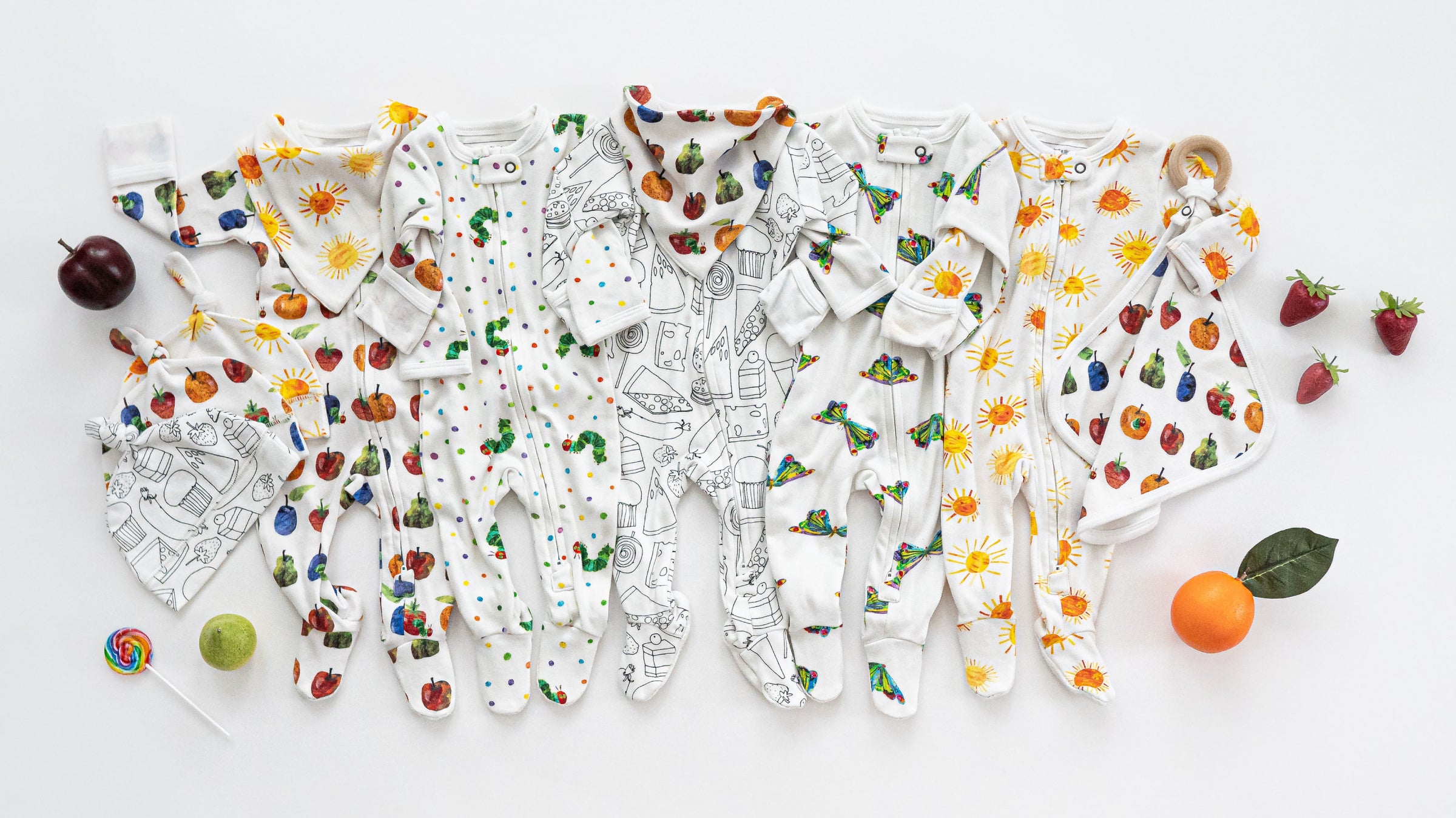Flat lay of multiple clothing pieces from the L'ovedbaby® x The Very Hungry Caterpillar™ collection.