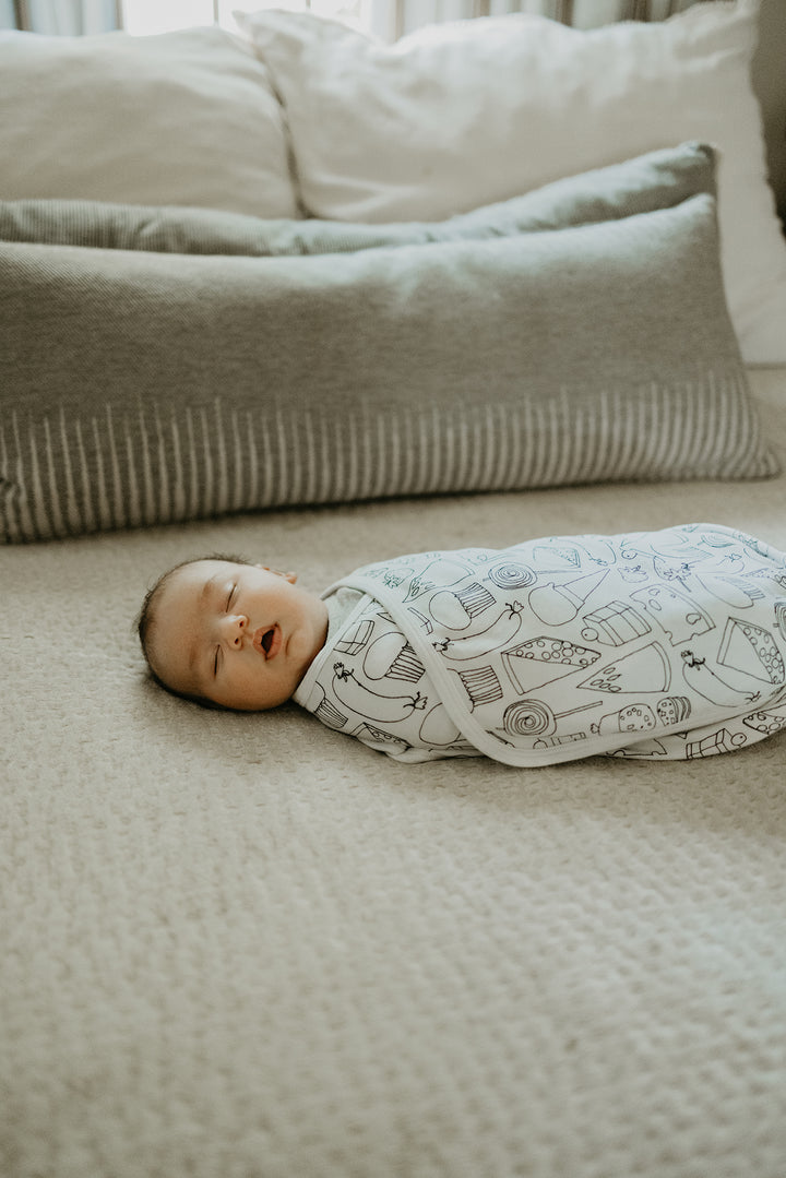 image of baby swaddled in snacks print blanket