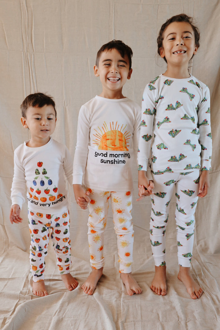 image of boy standing with siblings wearing kids pj set in "still hungry" print from very hungry caterpillar collection