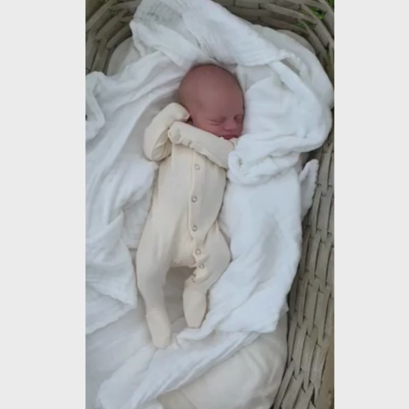 Child wearing Organic Snap Footie in Buttercream.