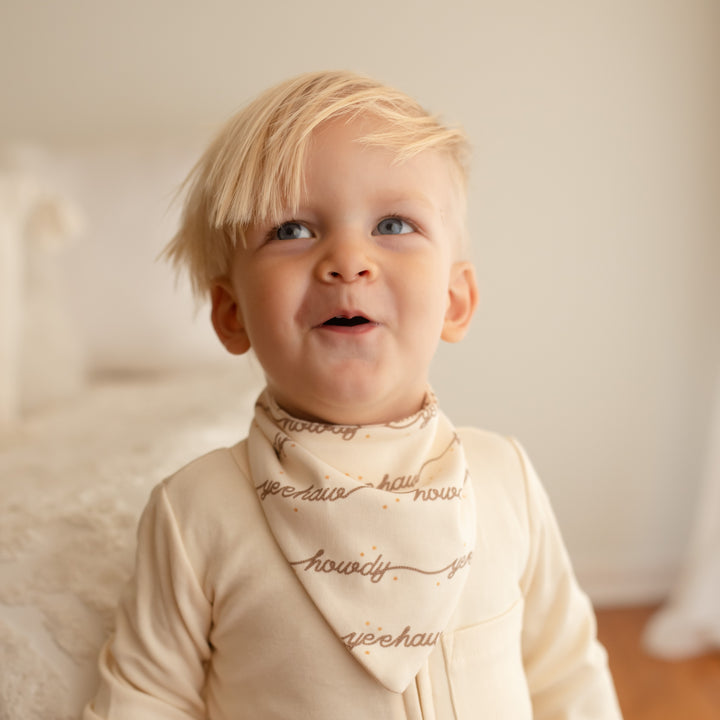Child wearing an Organic Bandana Bib in Howdy.