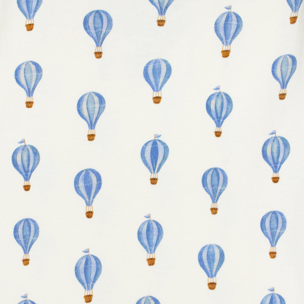 close up swatch view of blue hot air balloon print on buttercream fabric