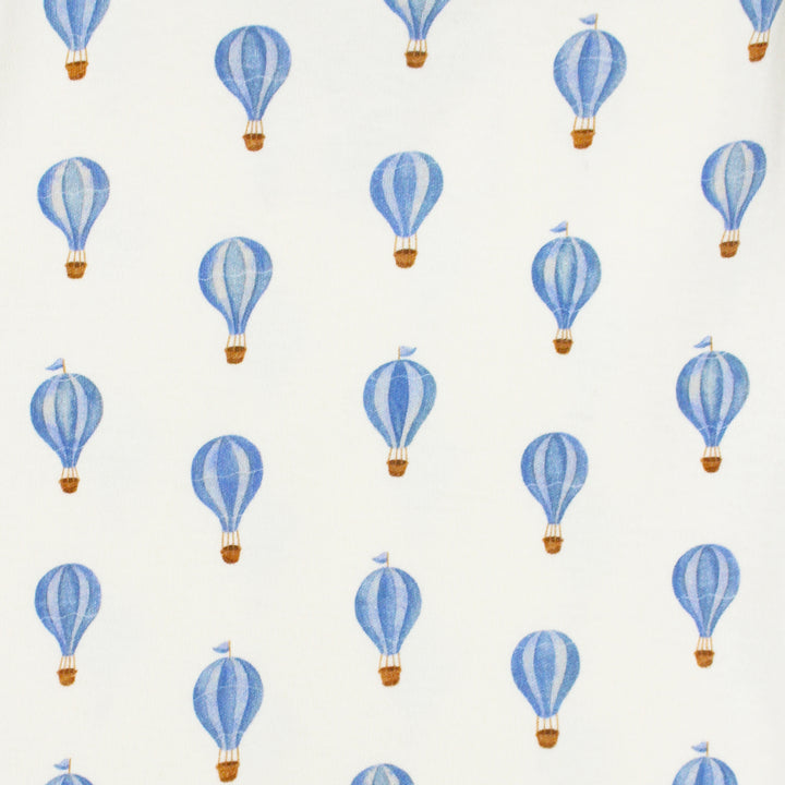 close up swatch view of blue hot air balloon print on buttercream fabric