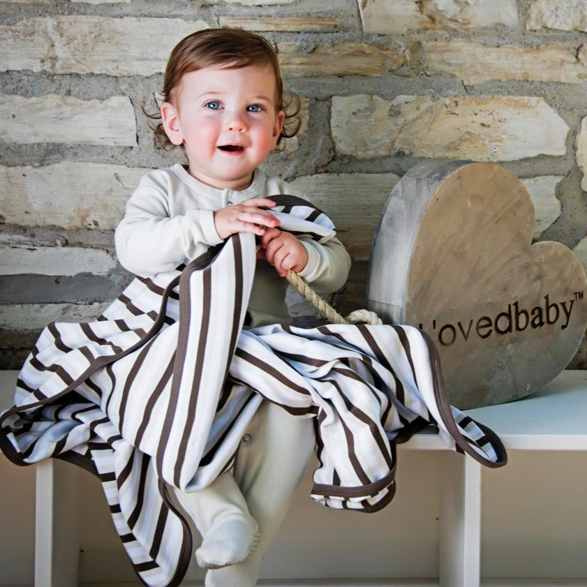 Child wearing Organic Swaddling Blanket in Bark Stripe.
