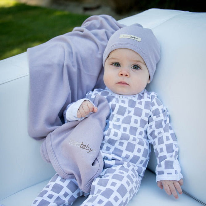Child wearing Organic Swaddling Blanket in Lavender.