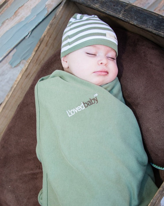 Child wearing Organic Swaddling Blanket in Sage.