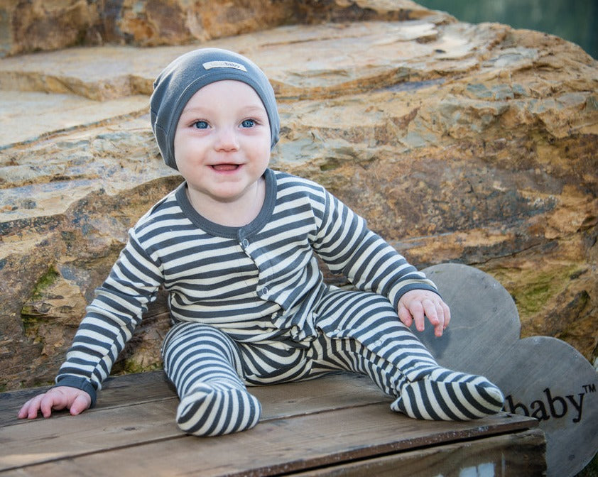 Child wearing Organic Snap Footie in Gray/Beige.