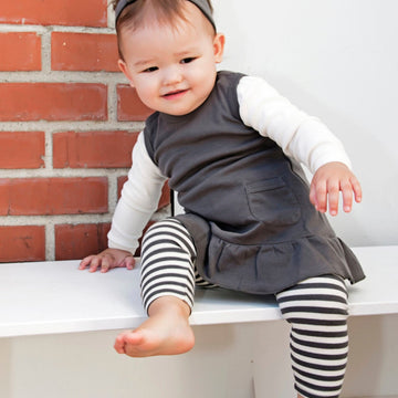Child wearing Organic Leggings in Gray/Beige.