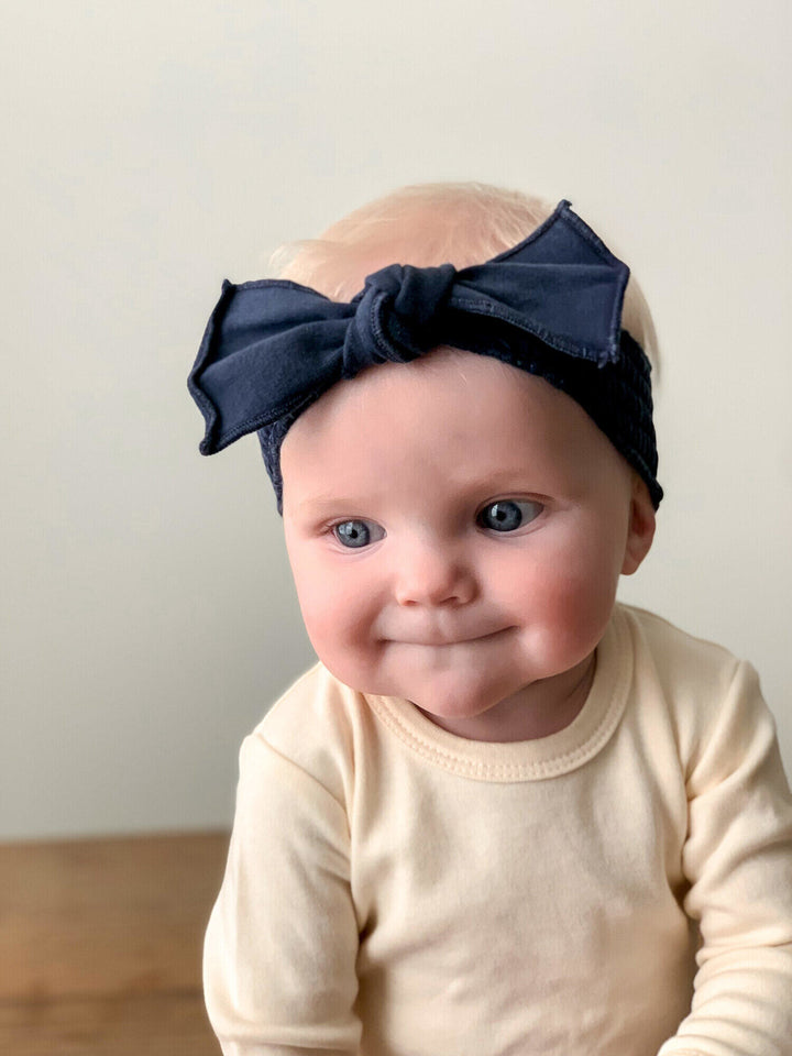 Child wearing Faux Denim Smocked Headband in Navy.