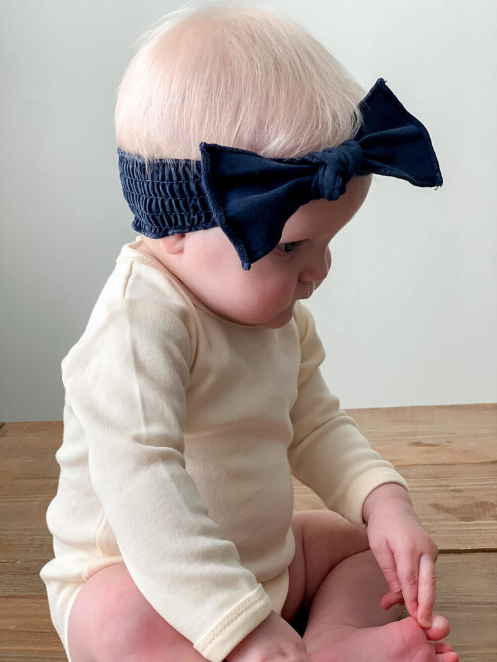 Child wearing Faux Denim Smocked Headband in Navy.