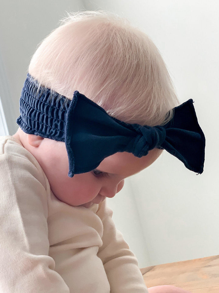 Child wearing Faux Denim Smocked Headband in Navy.