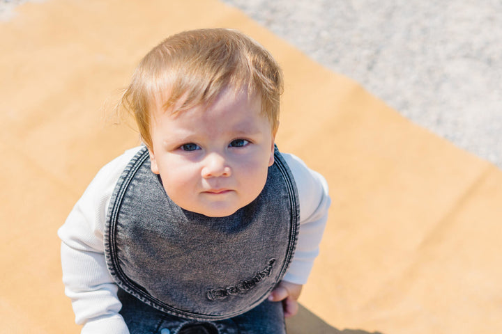 Child wearing Faux Denim Bib in Black.