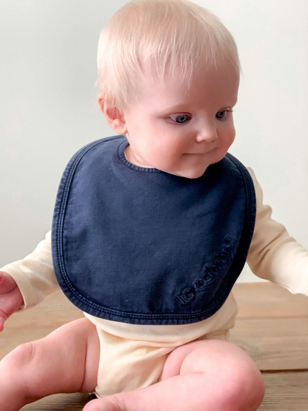 Child wearing Faux Denim Bib in Navy.