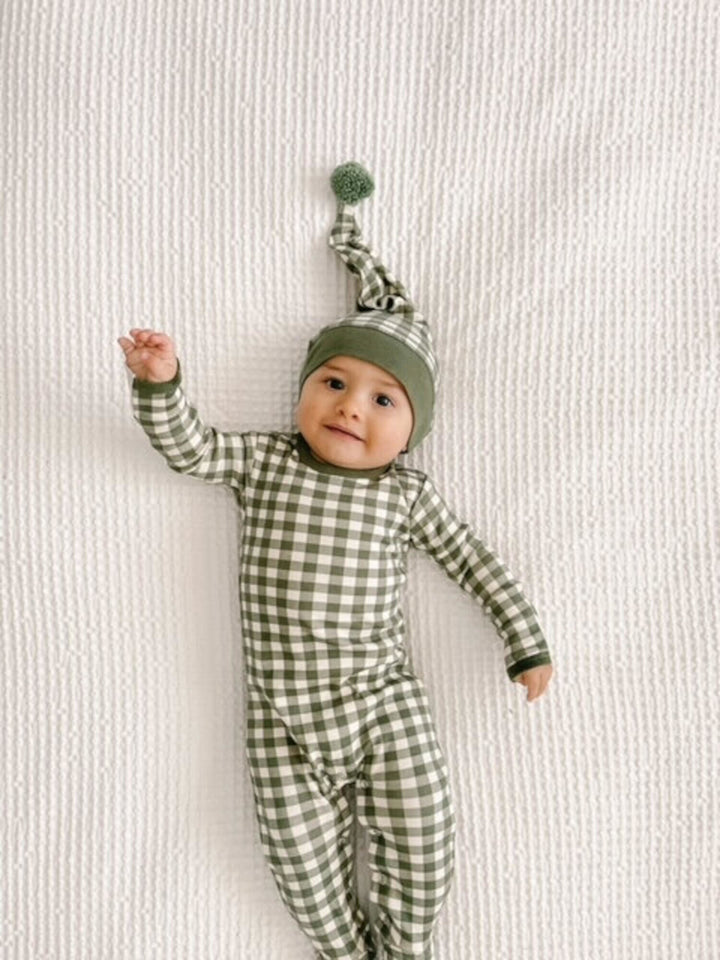 Child wearing Organic Holiday Footie & Cap Set in Christmas Eve Plaid.