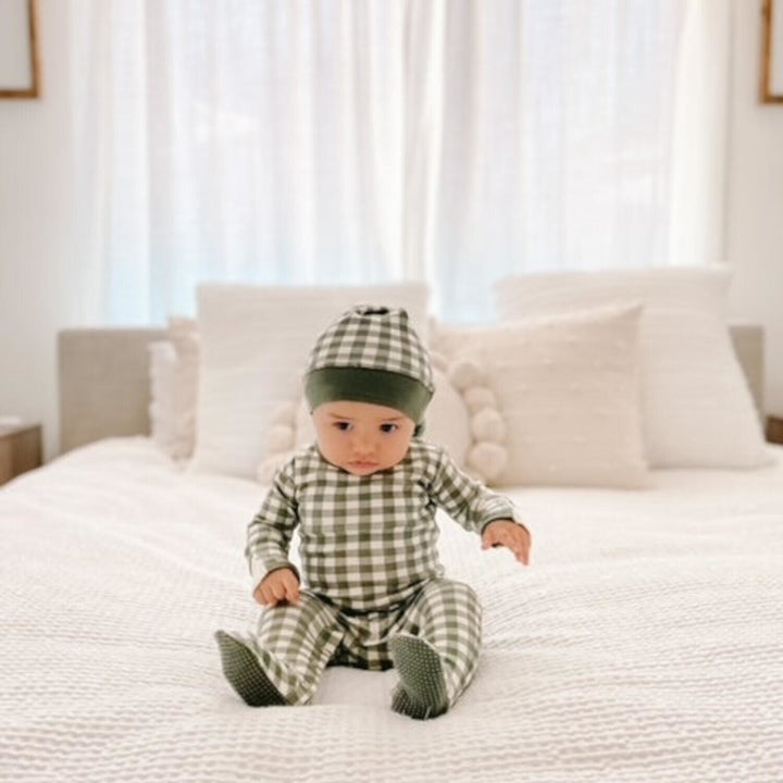 Child wearing Organic Holiday Footie & Cap Set in Christmas Eve Plaid.