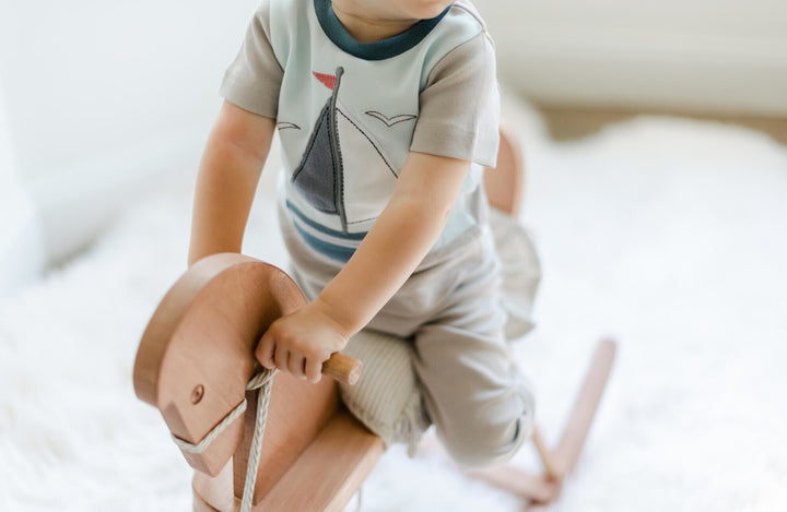Child wearing Kids' AppliquÃ© Short Sleeve PJ Set in Light Gray Sailboat.