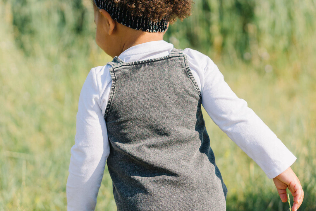 Child wearing Kids' Faux Denim Buckle Dress in Black.