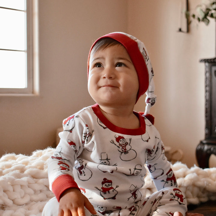 Child wearing Kids' Organic Holiday PJ & Cap Set in Snow Day.