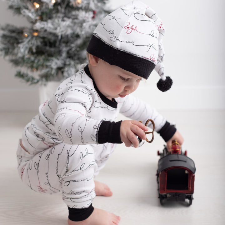 Child wearing Organic Holiday Kids' PJ & Cap Set in Writing Reindeer.