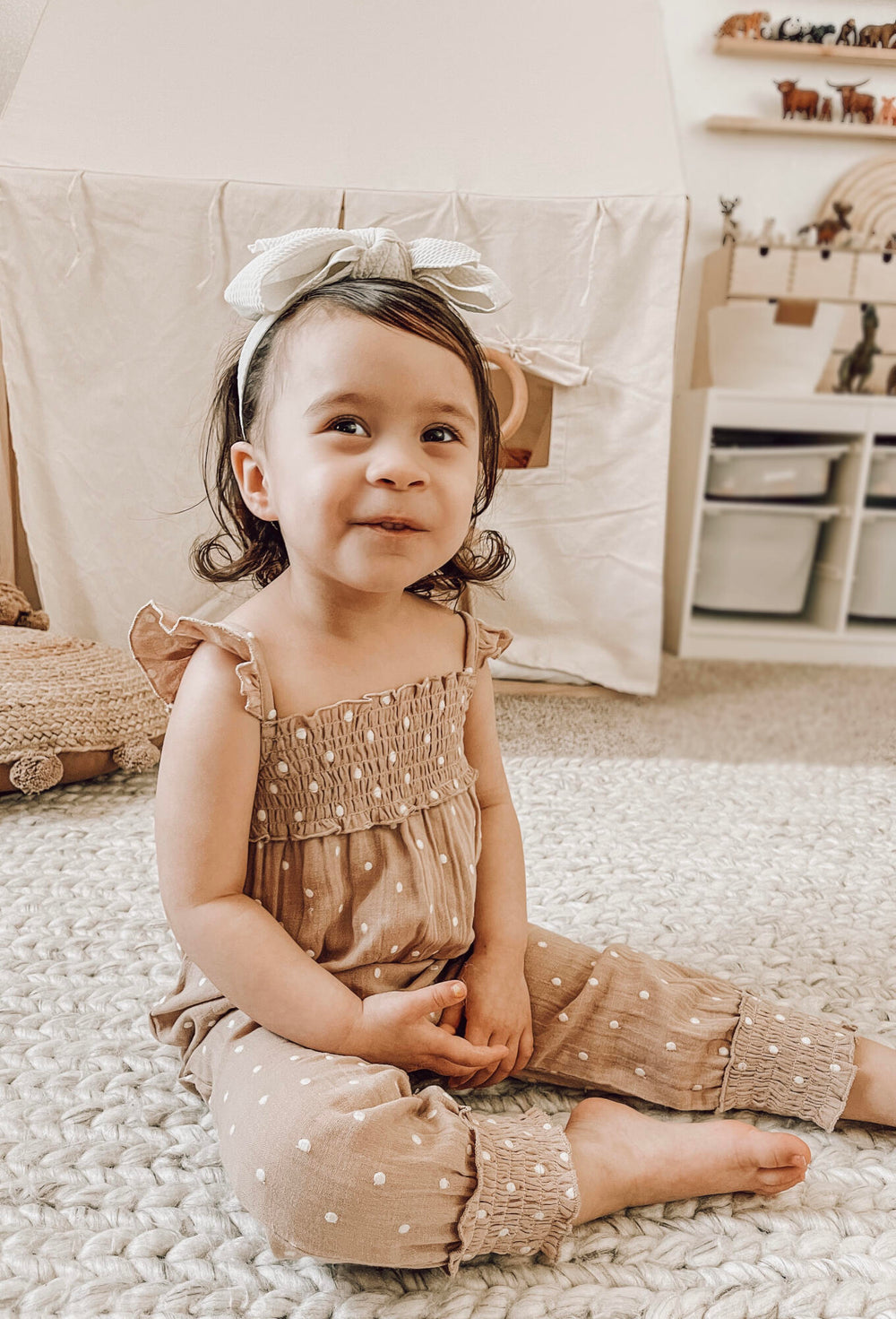 Child wearing Embroidered Muslin Sleeveless Romper in Wheat Dot.