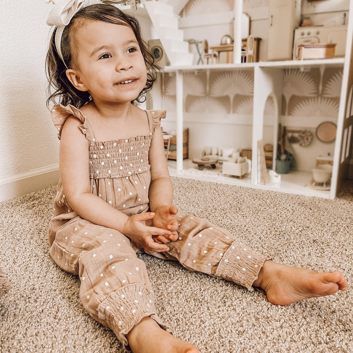 Child wearing Embroidered Muslin Sleeveless Romper in Wheat Dot.