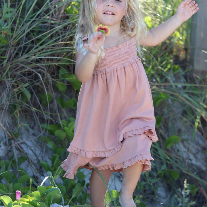 Child wearing Kids' Smocked Summer Dress in Adobe.