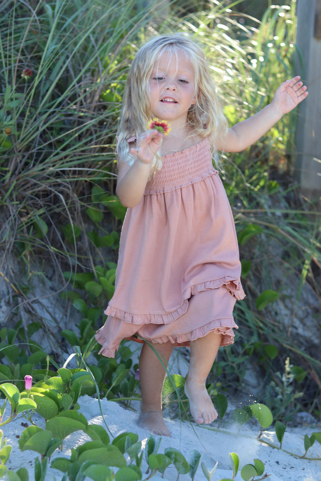 Child wearing Kids' Smocked Summer Dress in Adobe.