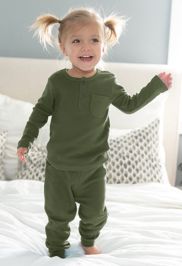 Child wearing Organic Thermal Kids' Lounge Set in Forest.