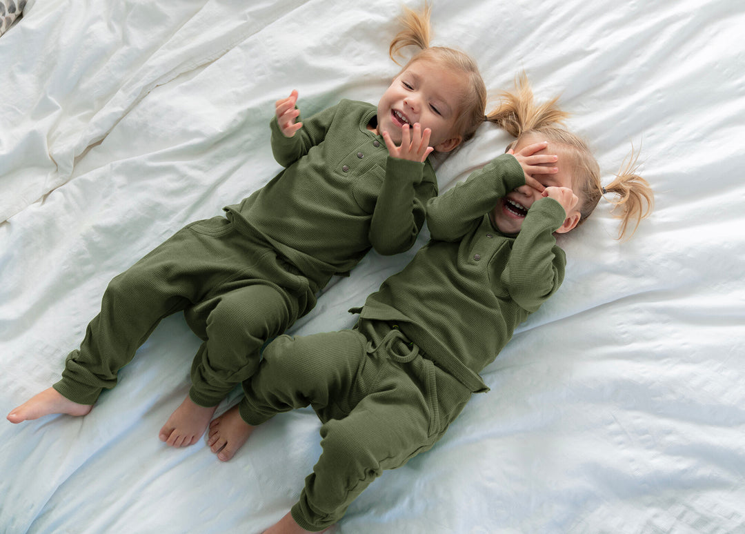Child wearing Organic Thermal Kids' Lounge Set in Forest.