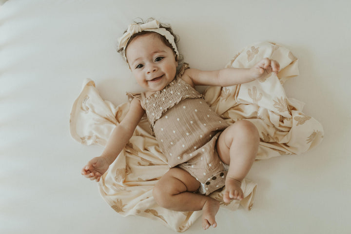 Child wearing Embroidered Muslin Sleeveless Bodysuit in Wheat Dot.