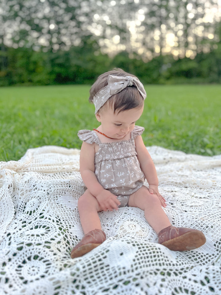 Child wearing Organic Muslin Sleeveless Bodysuit in Fawn Leaves.