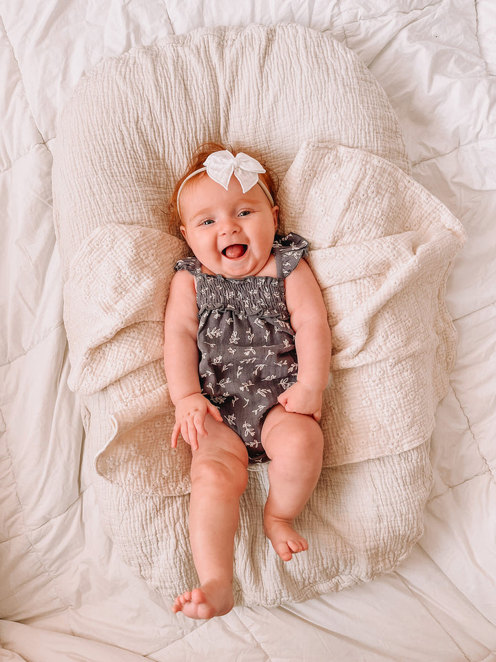 Child wearing Organic Muslin Sleeveless Bodysuit in Twilight Leaves.