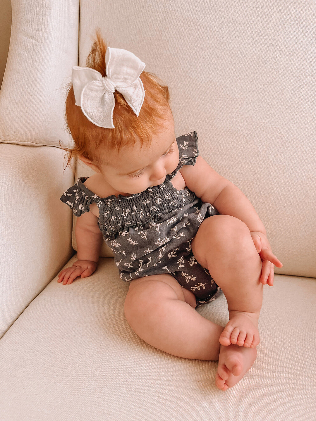 Child wearing Organic Muslin Sleeveless Bodysuit in Twilight Leaves.