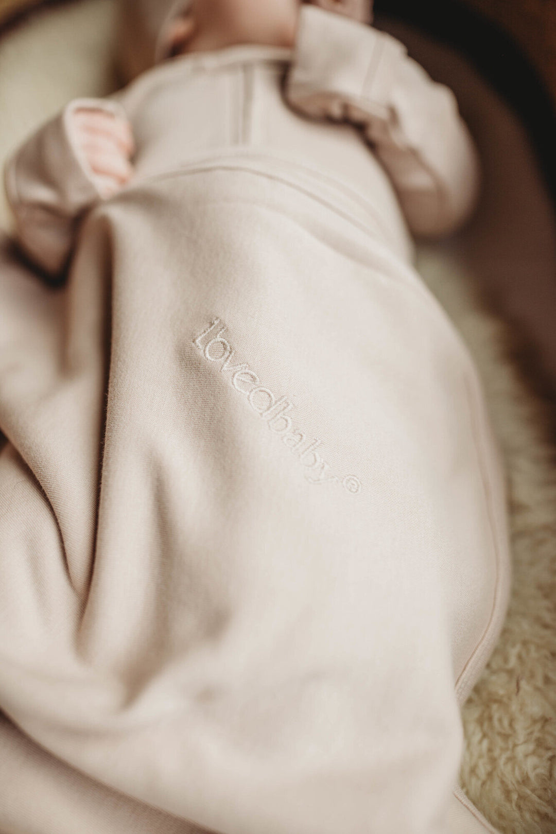 Child wearing Organic Swaddling Blanket in Oatmeal.