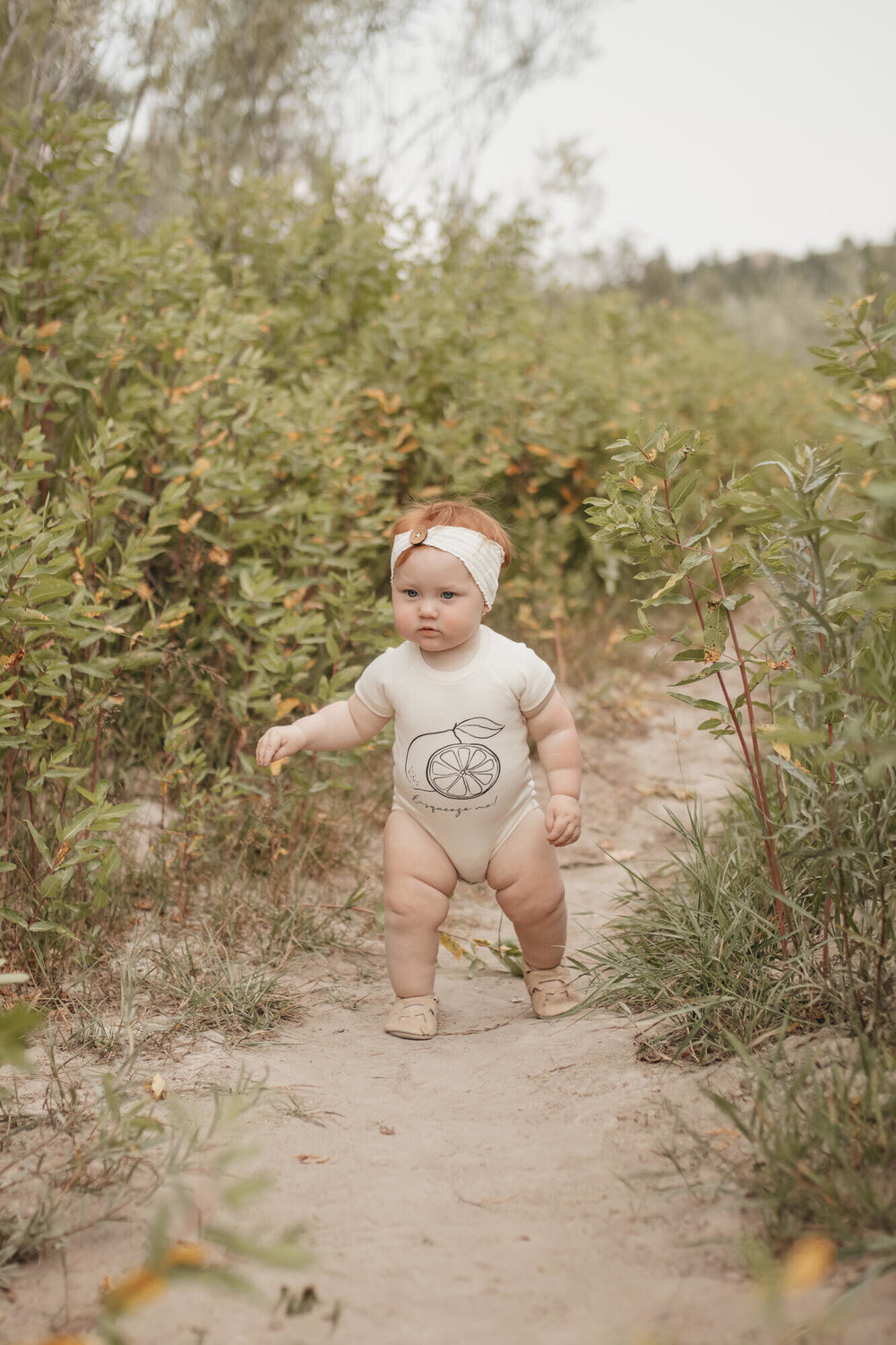Child wearing Raglan Bodysuit in Buttercream Lemon.