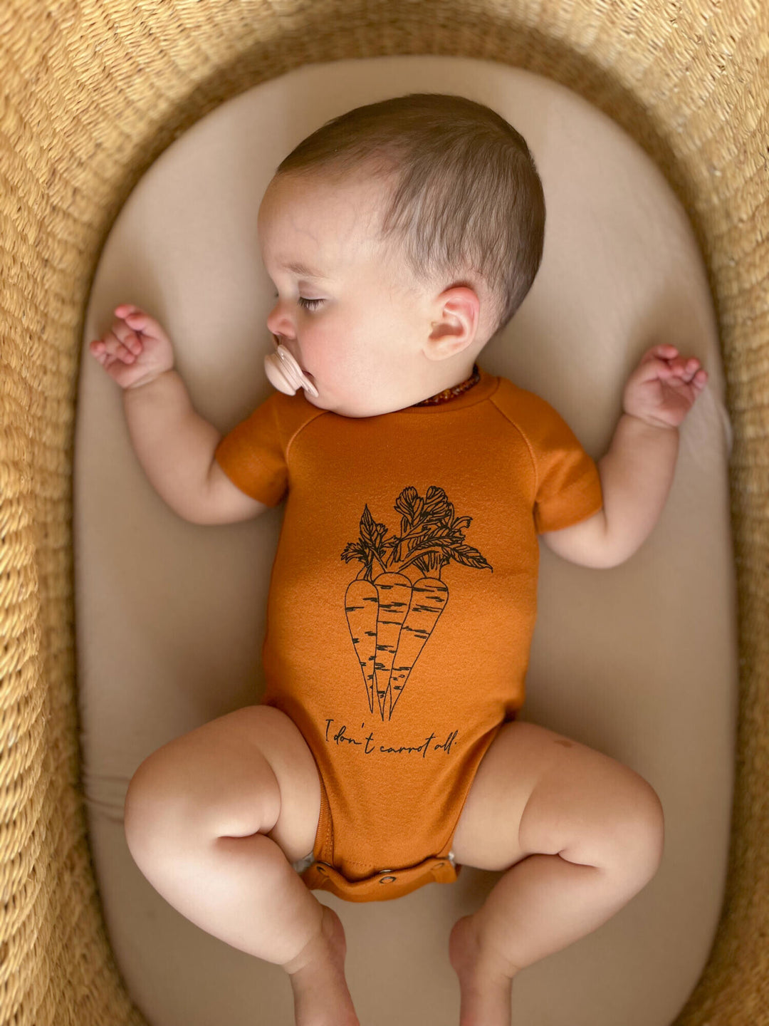 Child wearing Raglan Bodysuit in Butternut Carrots.