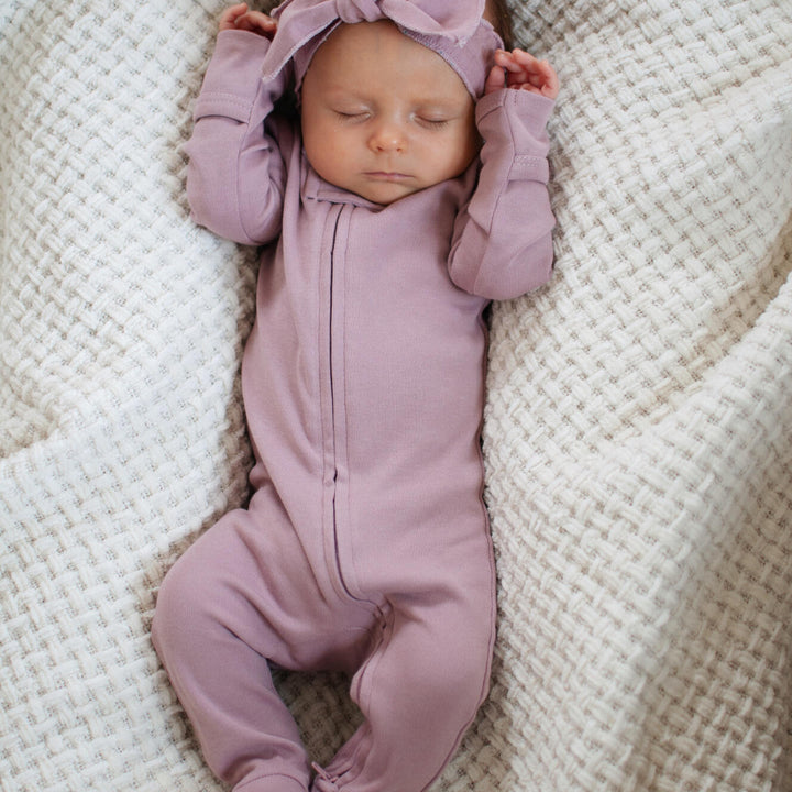 Child wearing Organic 2-Way Zipper Footie in Lavender.