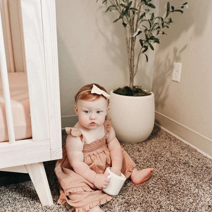Child wearing Smocked Summer Dress in Adobe.