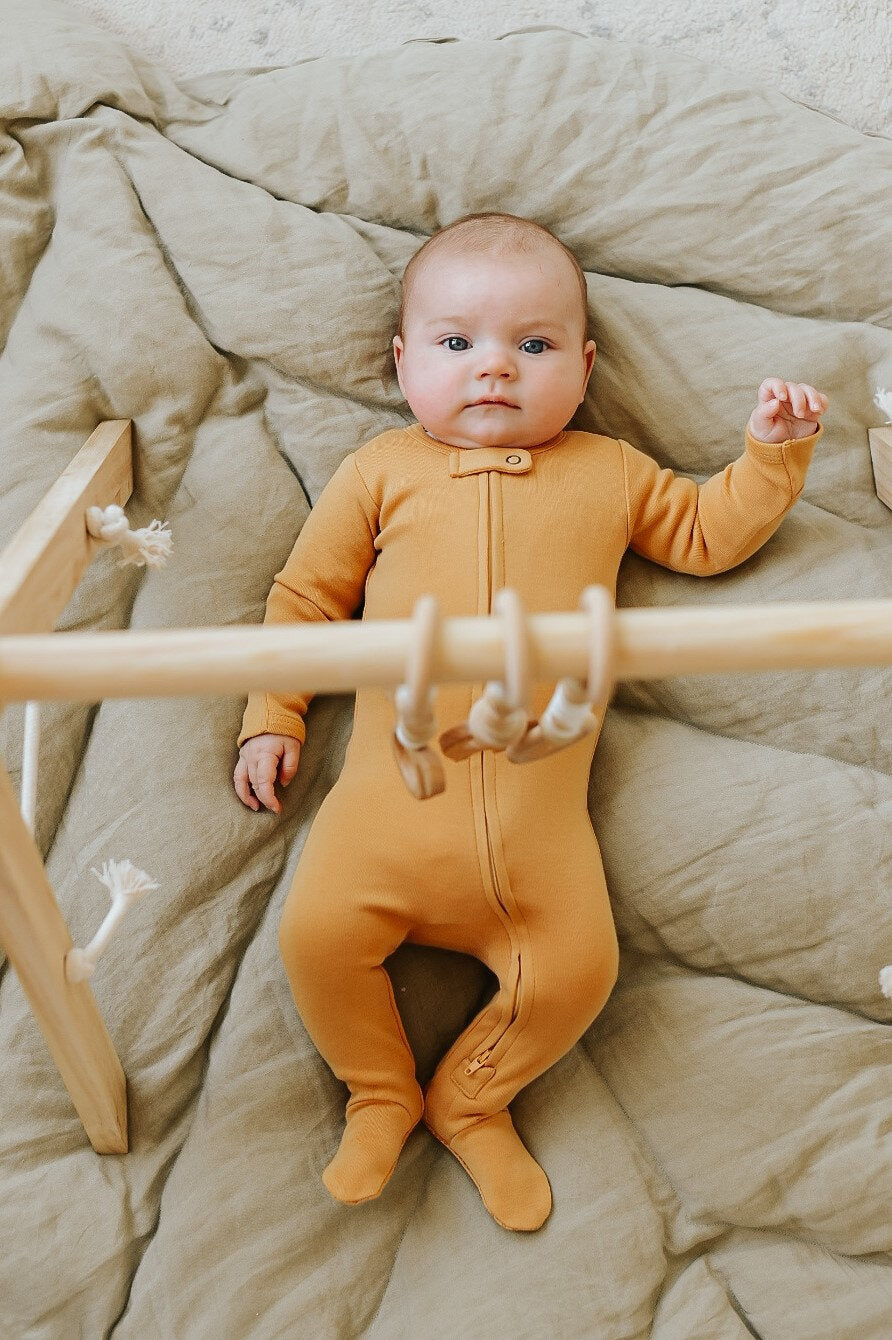 Child wearing Organic Zipper Footie in Honey.
