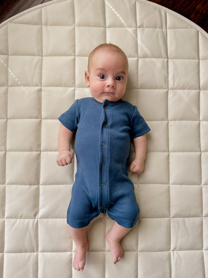 Child wearing Organic Short-Sleeve Romper in Blues.