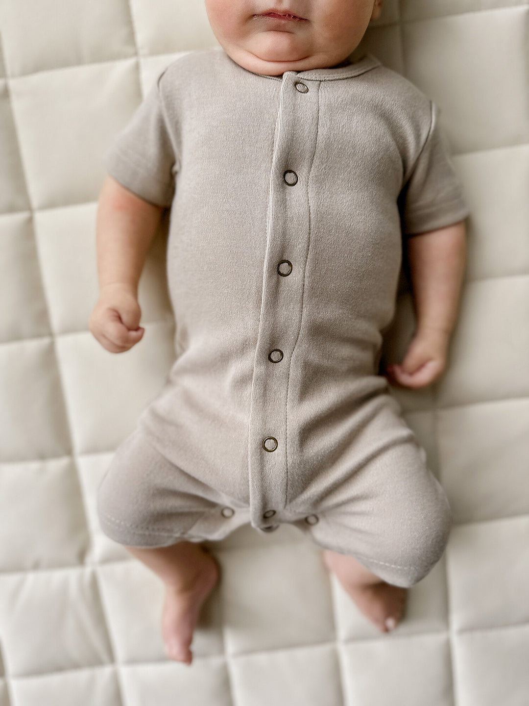 Child wearing Organic Short-Sleeve Romper in Neutrals.