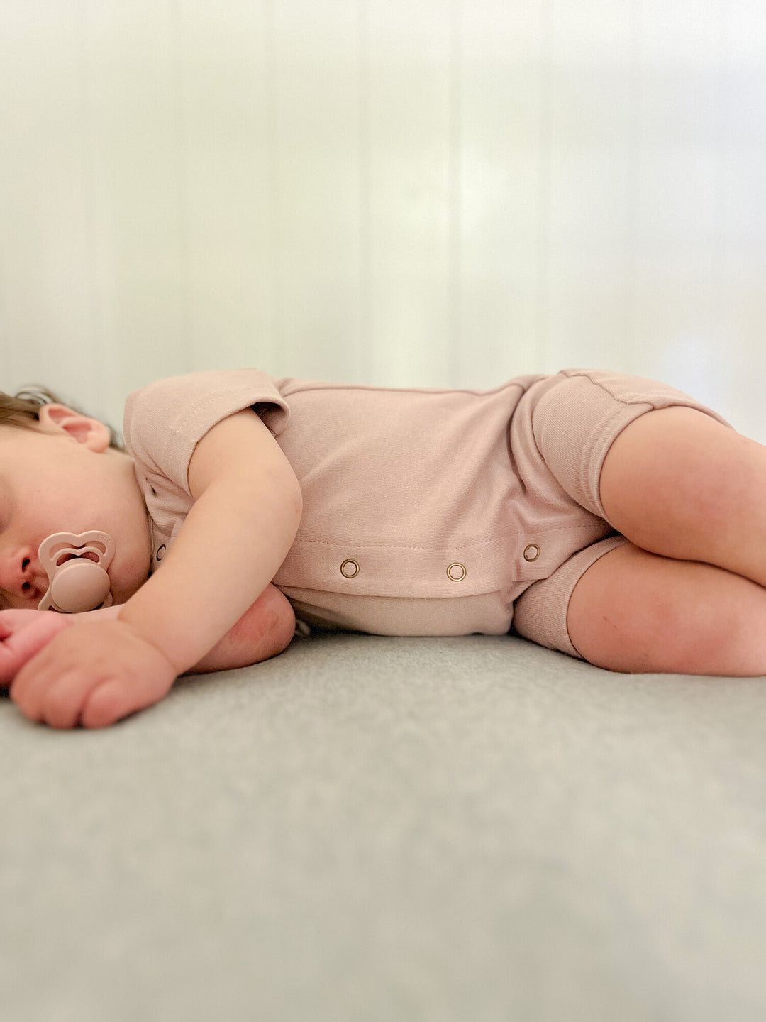 Child wearing Organic Short-Sleeve Romper in Pinks.