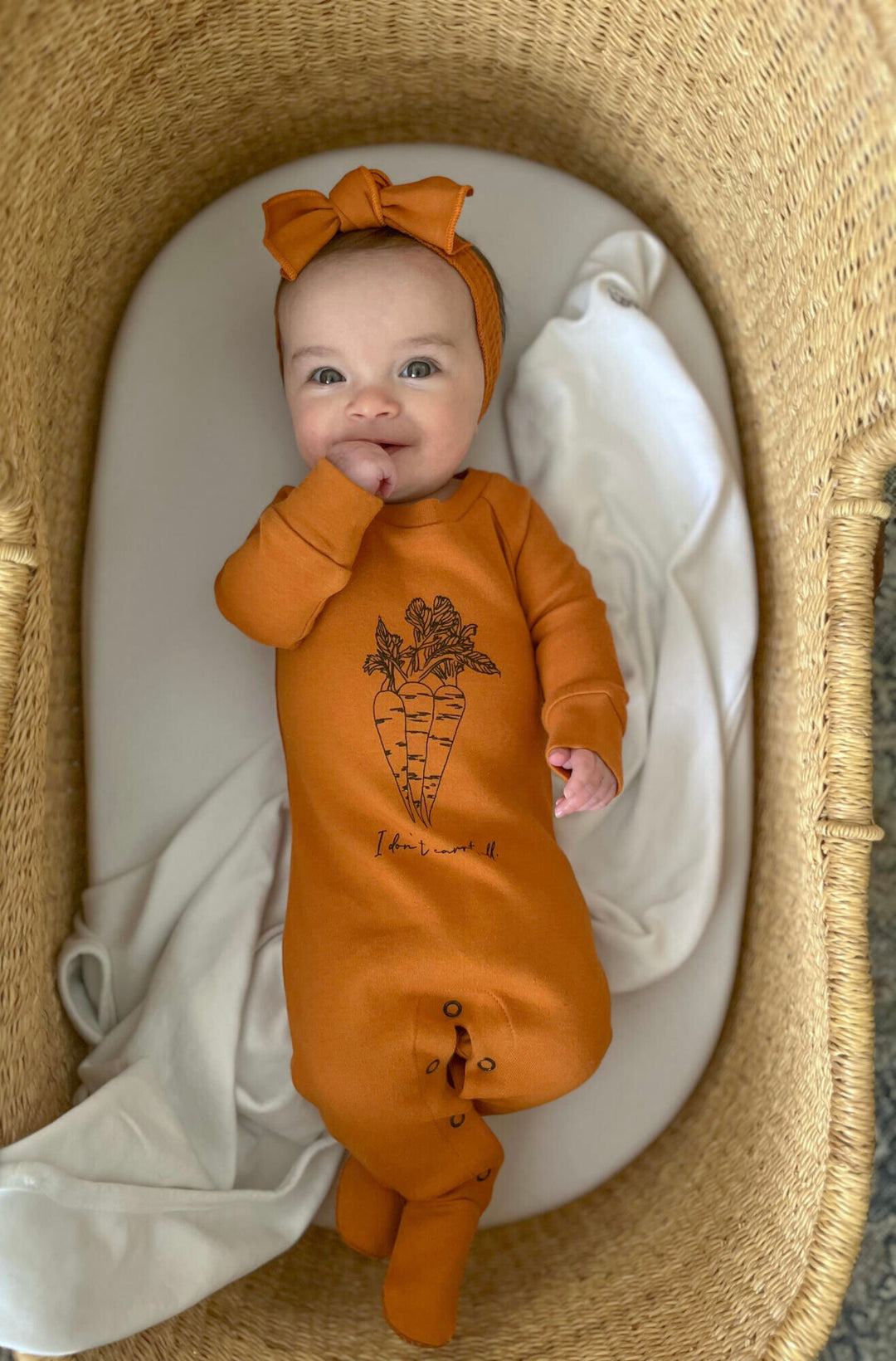 Child wearing Raglan Footie in Butternut Carrots.