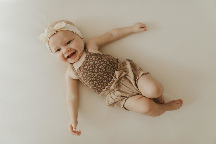 Child wearing Printed Criss-Cross Bodysuit in Latte Floral.