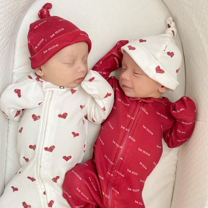 Child wearing Organic Banded Top-Knot Hat in Crimson Hearts.