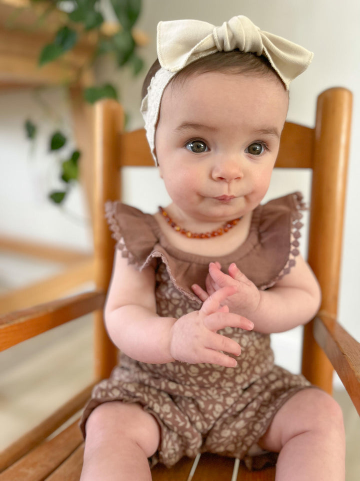Child wearing Printed Bubble Romper in Latte Floral. 